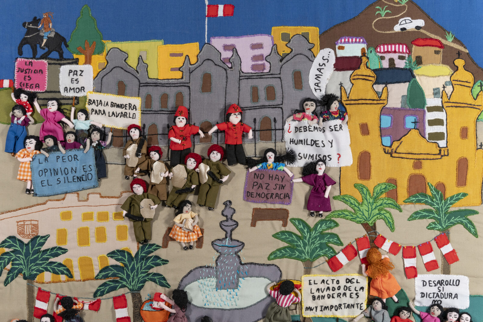 A close up image of a Peruvian story cloth depicting political protest.